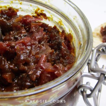 Spicy Tomato Chutney in a glass jar with a spoon