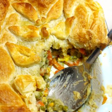 Vegan Vegetable Pie topped with puff pastry with a portion removed