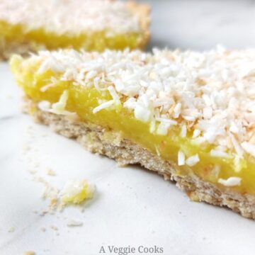 Vegan lemon slice topped with coconut on a white surface