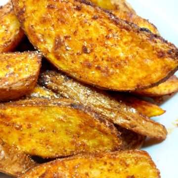 Spicy Potato Wedges piled up on a white plate