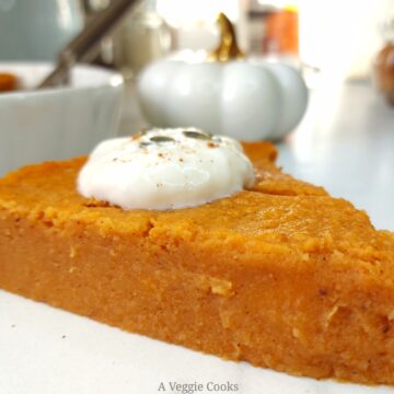 Slice of Vegan pumpkin pie with rest of pie in dish behind