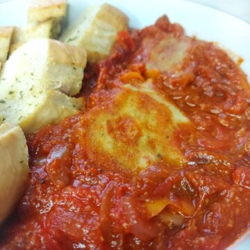 Piperade with vegan egg and garlic bread in a bowl